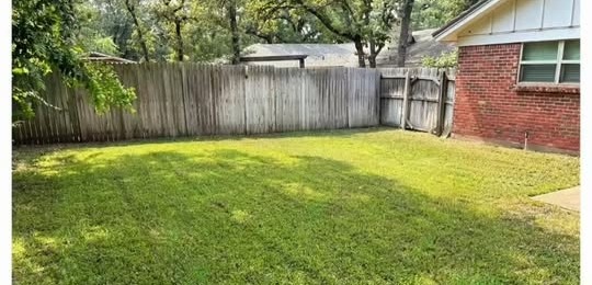 Freshly mowed and edged backyard lawn completed by Lonestar Elite Services